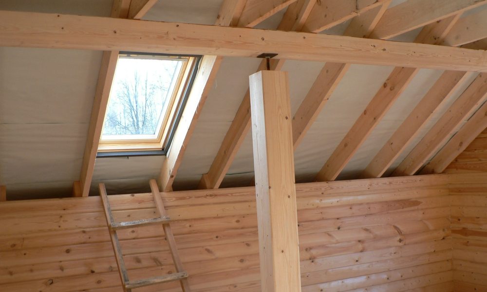 Construction of a wooden house, roof view with window.